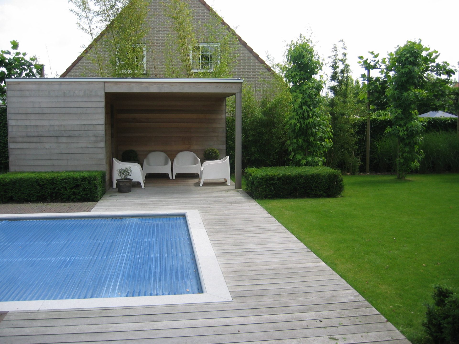 Zwembad met houten terras en poolhouse