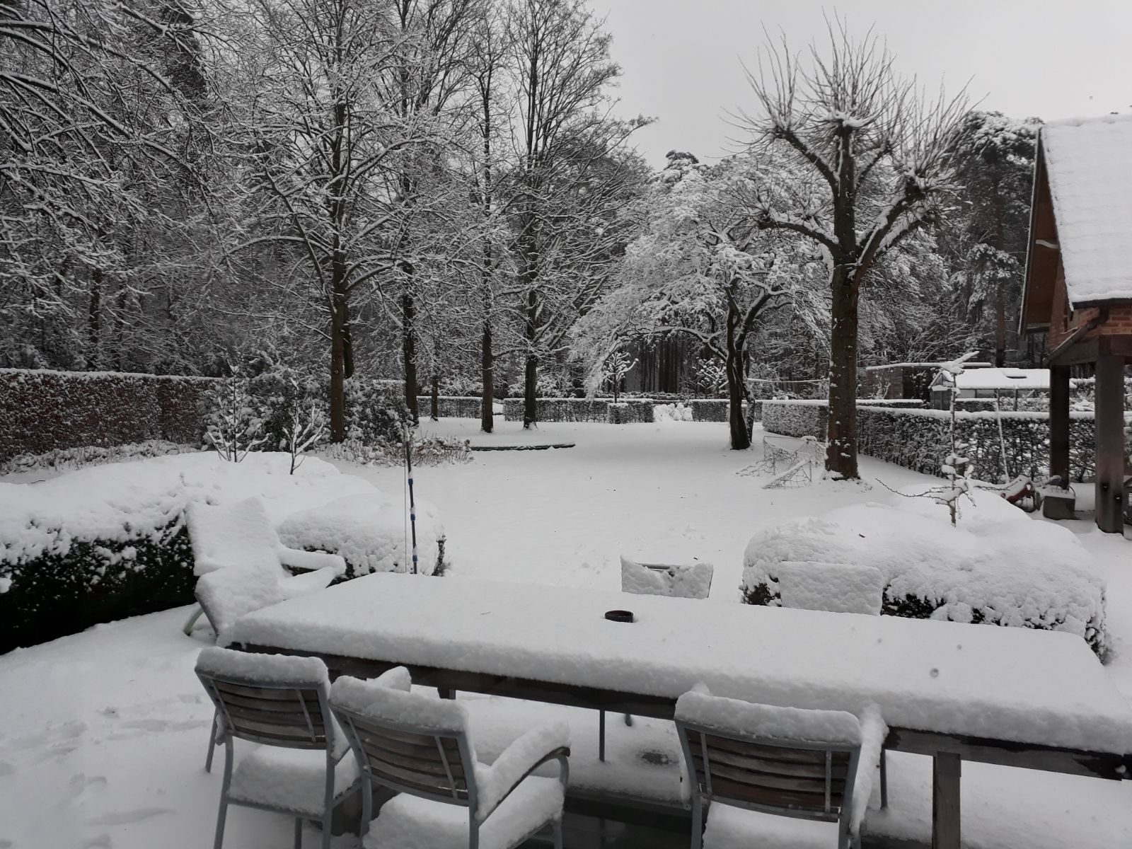 Besneeuwd terras met tuinmeubelen
